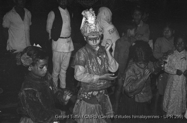 Kun pyaakhan, un théâtre disparu (1971-1975)  / Kun pyaakhan (kũ pyākhã) lors de l'Indra Jatra : le roi Dharmasturi entouré de ses deux reines, Dharmalakshmî et Dharmakeshvarî. 
Représentation annuelle du théâtre dansé d'enfants kun pyaakhan (kũ pyākhã) lors de l'Indra Jatra. Interprété par des garçons (moins de 16 ans) choisis parmi les quatre clans shivaïtes fondateurs du village, cet art performatif a aujourd'hui disparu / Toffin, Gérard  / Pyangaon (Lalitpur district), Népal 
