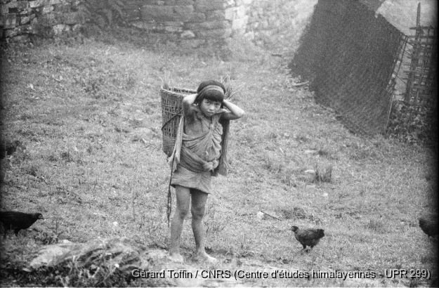 Fabrication des masques rituels (1974) / Enfant portant une hotte 
  / Toffin, Gérard  / Thimi (Bhaktapur district), Népal 