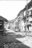 Rue unique de Pyangaon, avec séchage des épis de maïs après la récolte qui débute en août. On retrouve ce type de séchage, qui n'est pas seulement newar, ailleurs dans les collines du Népal. Sur la gauche, des plateformes (pati) de briques et de bois qui servent d'aires de repos. Généralement construites pas des particuliers à l'occasion de l'Indra Jatra, elles ont un usage tant rituel (l'image du dieu y est exposée une heure durant la procession) que profane (s'y pratiquent le tissage ou la vannerie)
 