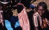 Lily and Betty Nungarrayi are painting a parata (dish) with NGARRKA (Initiated man) designs; purpala