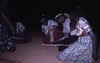Women dance KAYAKAYA on their knees. Barbara Gibson Nakamarra act as manager with a stick.