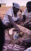 Women paint dish with NGURLU (Seed) design